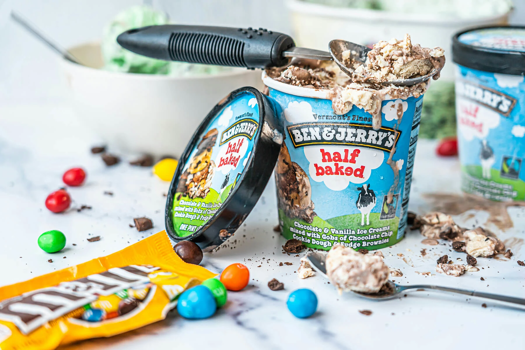 Ben & Jerry's Half Baked ice cream pint open with a spoon, packaging showing the playful cow and farm illustrations