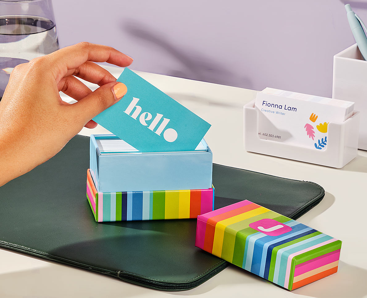 A hand holding several premium Mohawk Superfine business cards.