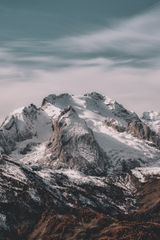 Snow-covered mountain peaks beneath a cloudy sky